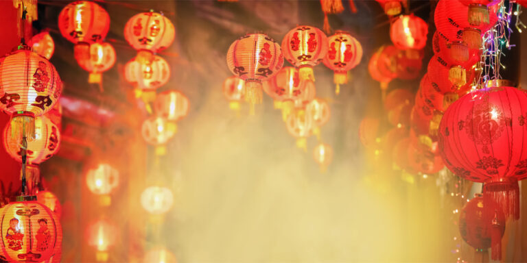 Czerwone chińskie lampiony papierowe ozdobione złotymi wzorami, wiszące nocą podczas obchodów Chińskiego Nowego Roku